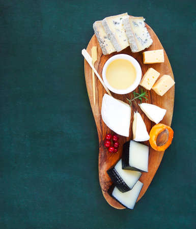 Cheese, honey and fruits. Plate antipasti snack on the wooden board 