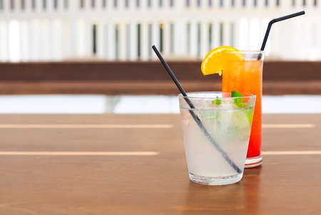 Cocktail glasses on wooden background. Tequila sunrise, mojito