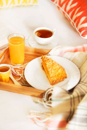 Cozy breakfast in bed with tea and orange juiceの写真素材