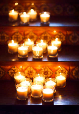 Burning small candles in glasses, romantic decoration in vintage style, selective focus. Blurred backgroundの写真素材
