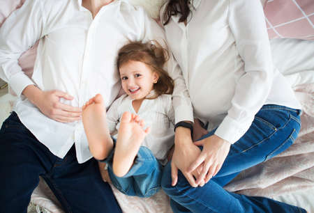 Happy pregnant woman with her husband and little daughter. Close upの写真素材