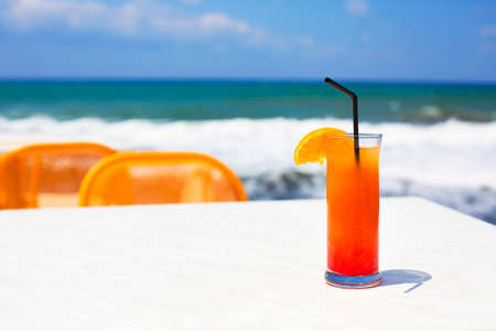 Cocktail glass on sea background. Tequila sunriseの写真素材