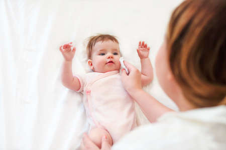 Young woman in the room with baby. Baby care conceptの写真素材