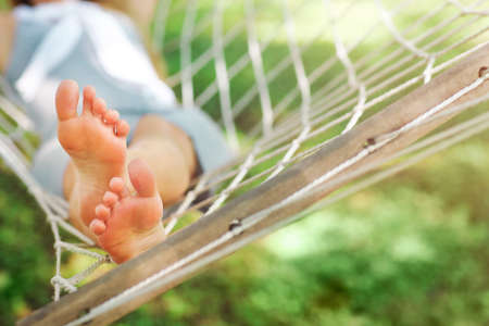 Young woman relaxing on hammock outdoorの写真素材