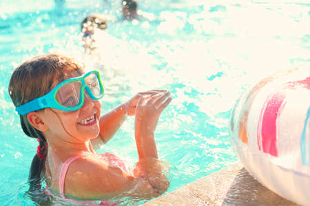 One small girl having fun in outdoor pool. Summer vacation conceptの写真素材