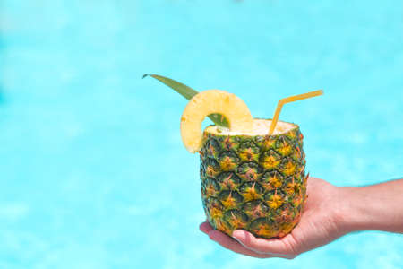 Exotic pineapple cocktail near pool. Pina colada