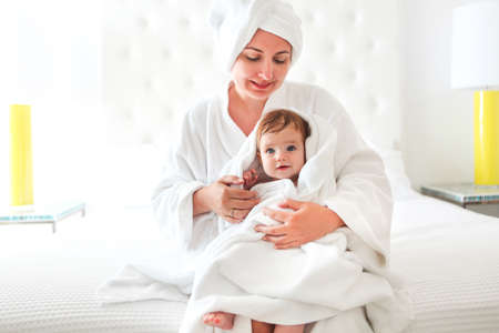 Young woman in the room with baby after bath. Baby care conceptの写真素材