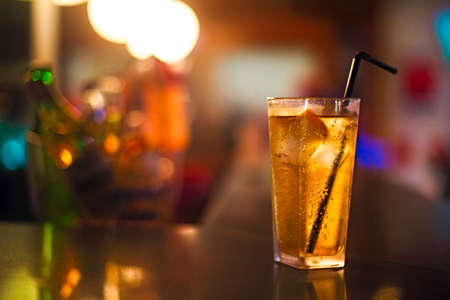 Cocktail glass on bar counter in nightclub
