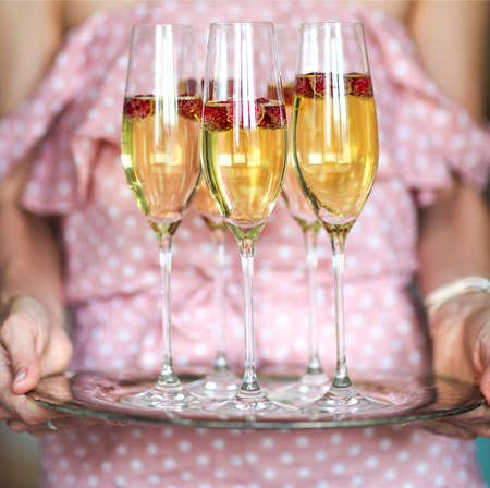 Young caucasian woman with champagne glasses on tray