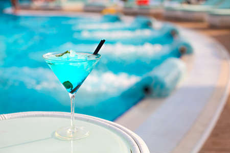 Exotic alcohol cocktail on white table on poolsideの写真素材