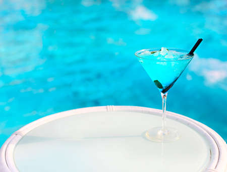 Exotic alcohol cocktail on white table on poolsideの写真素材
