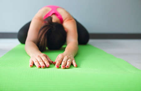 Young pretty woman doing fitness exercises on the floor