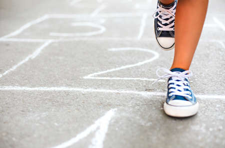 Kid playing hopscotch on playground outdoors, children outdoor activitiesの写真素材
