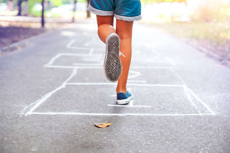 Kid playing hopscotch on playground outdoors, children outdoor activitiesの写真素材