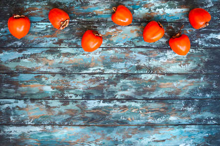 Top view of ripe persimmons on wooden rustic table with copy spaceの写真素材
