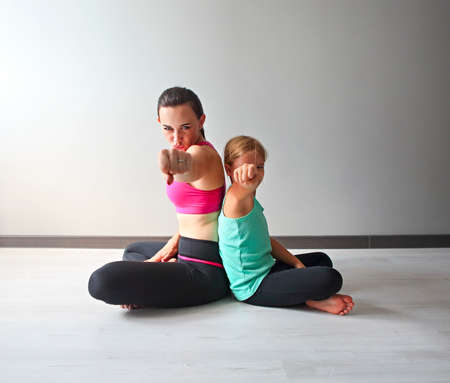 Young woman having fun with kid after yoga. Family sport conceptの写真素材