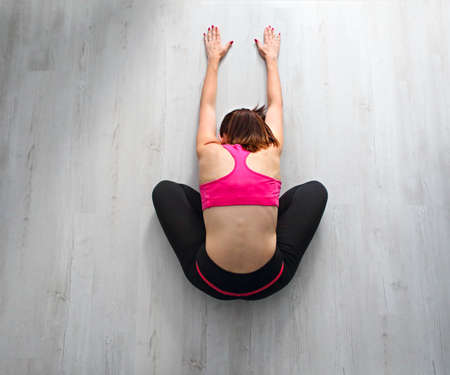 Young pretty woman doing fitness exercises on the floor at home