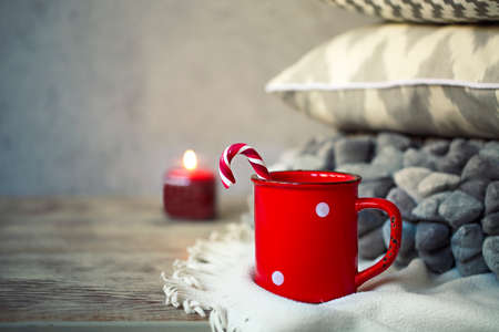 Cup of coffee staying by thepillows on the wooden table. Christmas conceptの写真素材