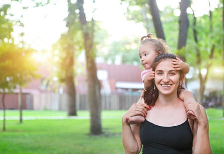Young woman exercising with her baby girl in the parkの写真素材