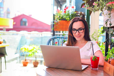 Young woman working on computer in the outdoors cafeの写真素材