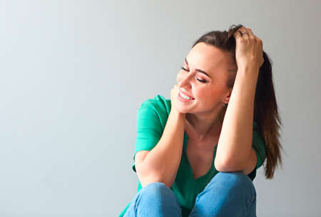 Sexy young woman sitting on the floor and smilingの写真素材