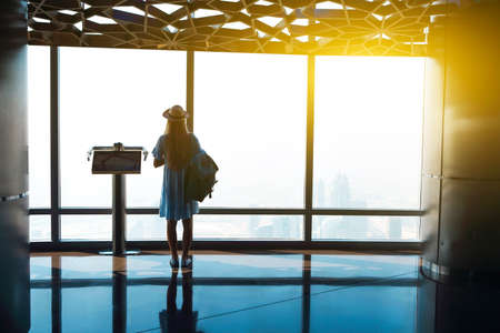 Silhouette of the girl tourist at window of skyscraper of the Burj Khalifa in Dubai, United Arab Emirates, UAEの写真素材