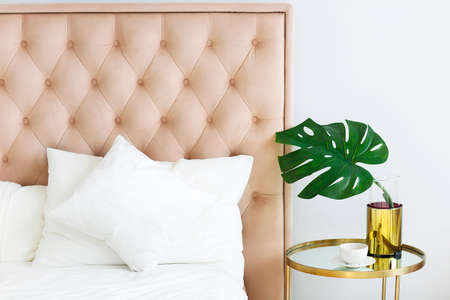 Modern bedroom with table side and pillows and coffee. Closeup