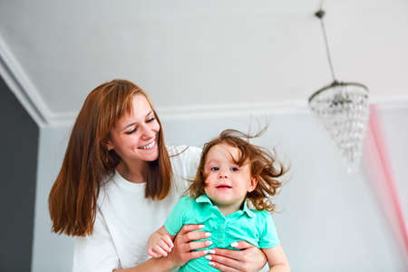 Young woman having fun with daughter indoors