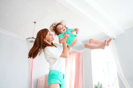Young woman having fun with daughter indoorsの写真素材