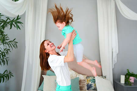 Young woman having fun with daughter indoorsの写真素材