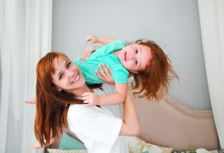Young woman having fun with daughter indoorsの写真素材