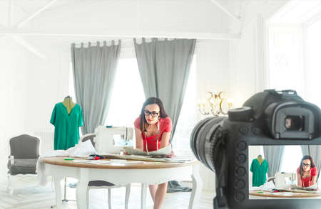 Young fashion designer recording video about dress for new vlogの写真素材