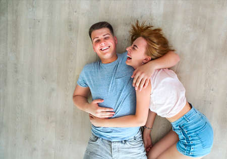 Happy young couple at home relaxing on the floorの写真素材