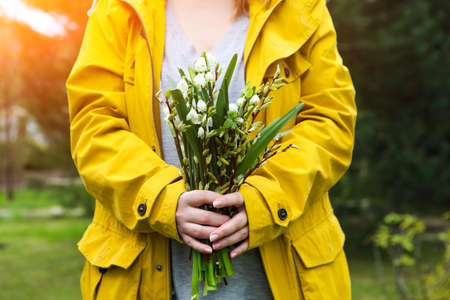 Young woman with lily of the valley. Girl on nature. Spring flowers. Close upの写真素材