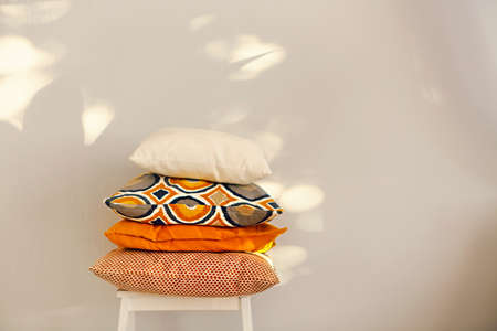 Colorful pillows on the chair on light backgroundの写真素材