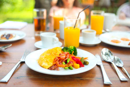 Omelet with pepper, cucumber, bakon and salad on the table outdoorsの写真素材