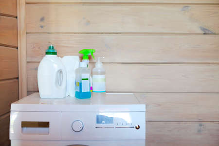 Plastic cleaning supplies on washing machine on the wooden background. Close upの写真素材