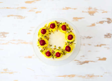 Beautiful happy birthday cake with mascarpone decorated with raspberry, pistachio and candles on the...