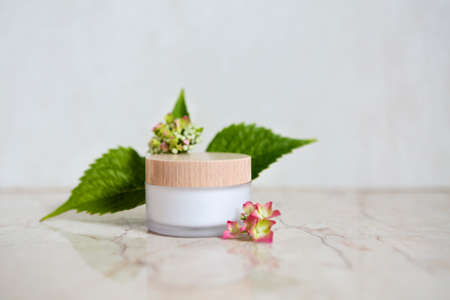 Face cream and hydrangea in the bath. Close up