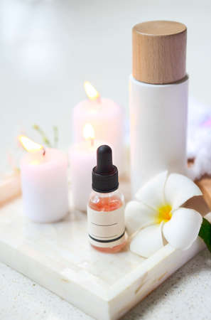 Face cream, serum, lotion, moisturizer and face oil among white frangipani in the bathの写真素材
