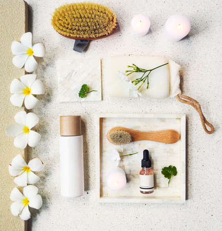 Face cream, serum, lotion, moisturizer and face oil among white frangipani in the bath. Top viewの写真素材