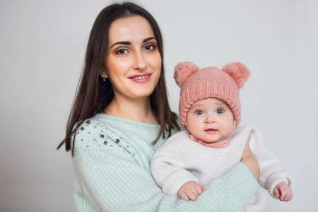 Mother and baby playing and smiling, happy family indoors at winter season 