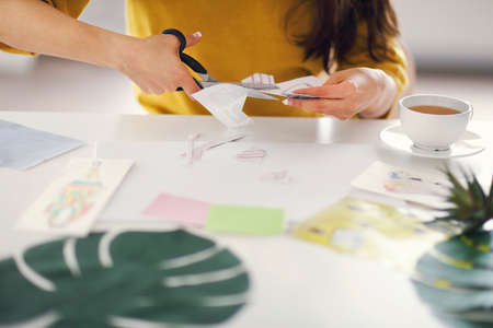 Young brunette woman creating her Feng Shui wish map using scissorsの写真素材