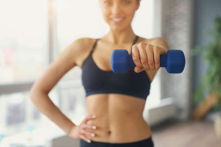 Young attractive sportswoman doing fitness exercises at sport gym