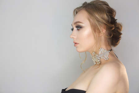 Portrait of a beautiful young blonde woman. Woman with fashion hairstyle and make up. Trendy black lacy choker with cristalsの写真素材