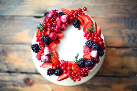 Christmas Cake decorated with berries on the wooden rustic tableの写真素材