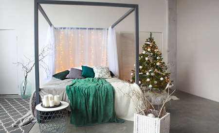 Christmas design of the bedroom. Christmass tree with presents in the room の写真素材