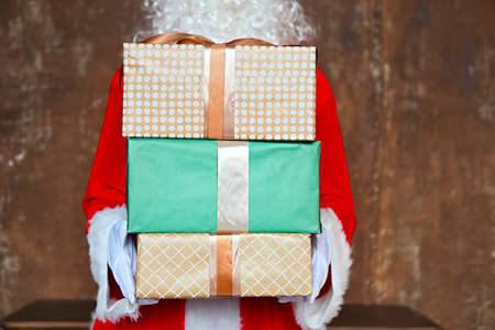 Santa Claus secretly putting gift boxes under the Christmas tree. Xmasの写真素材