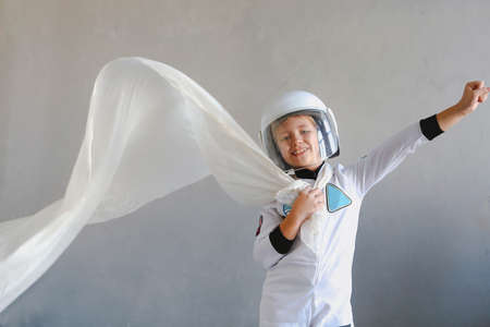 Astronaut futuristic kid girl with white full length uniform and helmet. Dream, future, travel and discovery conceprの写真素材