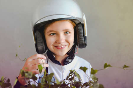 Astronaut futuristic kid girl wearing white uniform and helmet standing by the ivy plantの写真素材